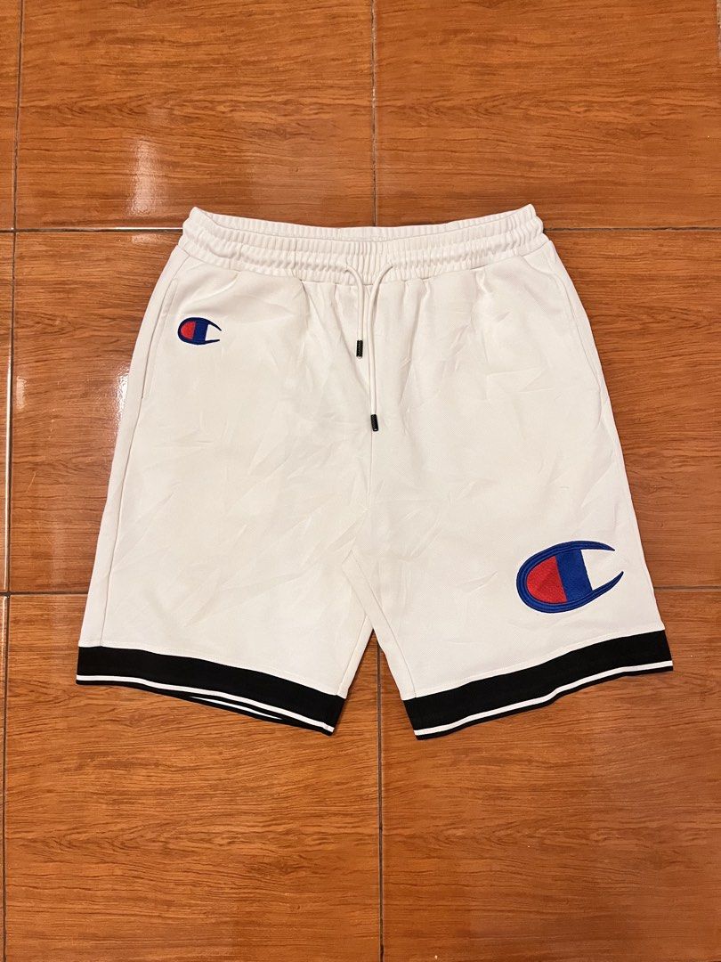 Champion White Athletic Shorts XXL (Category: Shorts) located in Calasiao. Submitted by cristinabarongan5 (Listing ID 1464835945, Image 1). Description: - Brand: Champion - Color: White with black & white striped cuffs - Size: XXL - Material: 100% nylon body, 100% cotton lining - Features: Elastic waistband, adjustable drawstring, dual side logos, and vertical script logo - Origin: Made in Vietnam - Condition: Clean and ready to wear - Size 32-38
