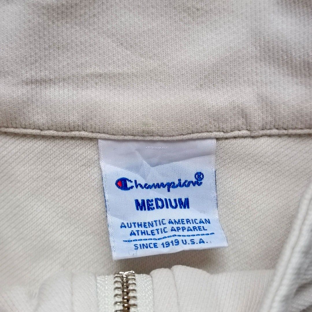 Champion White Half-Zip Short Sleeve Top Medium (Category: Shirts) located in Manila. Submitted by caps08 (Listing ID 1464883450, Image 2). Description: - Brand: Champion - Style: Half-zip short sleeve top with mock neck collar - Size: Medium (M) - Color: White - Features: Dual front flap pockets, adjustable drawstring hem - Branding: Embroidered Champion script logo on right chest pocket and small patch on left sleeve.