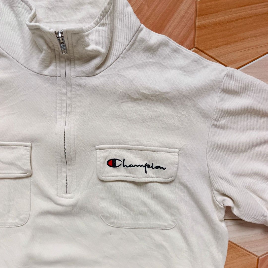Champion White Half-Zip Short Sleeve Top Medium (Category: Shirts) located in Manila. Submitted by caps08 (Listing ID 1464883450, Image 3). Description: - Brand: Champion - Style: Half-zip short sleeve top with mock neck collar - Size: Medium (M) - Color: White - Features: Dual front flap pockets, adjustable drawstring hem - Branding: Embroidered Champion script logo on right chest pocket and small patch on left sleeve.