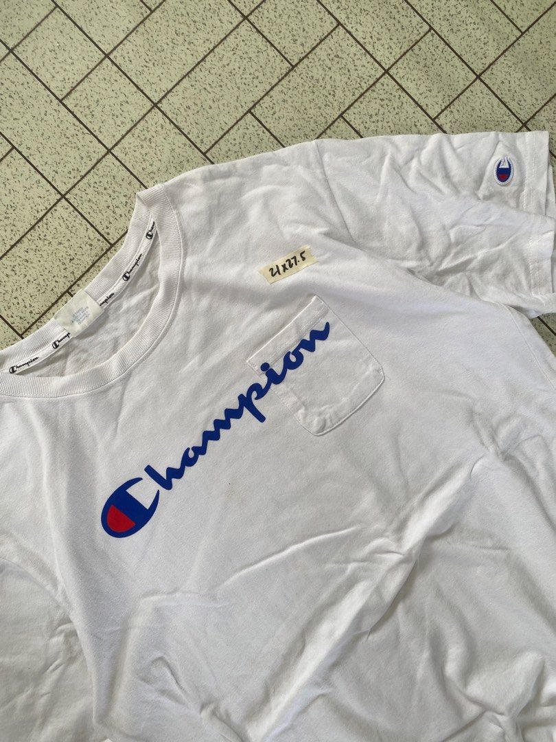 Champion White Script Logo Pocket T-Shirt X-Large (Category: Tshirts & Polo Shirts ) located in Manila. Submitted by sepamorash53558 (Listing ID 1464807467, Image 2). Description: - Brand: Champion - Color: White - Size: X-Large (XL) - Features: Large blue script logo, chest pocket, left sleeve embroidered patch, and branded inner collar tape - Measurements: ~21" pit-to-pit, ~27.5" length - Condition: Excellent.