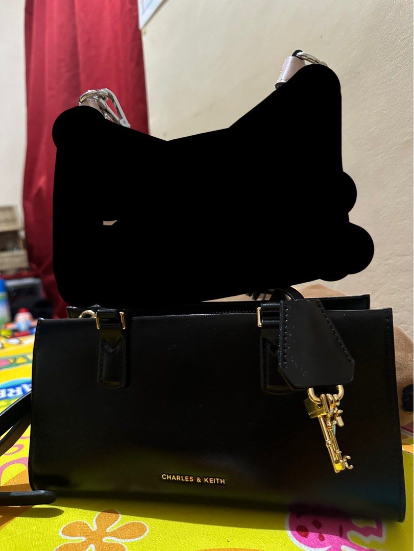 Charles & Keith Kerry Top Handle Bag Black (Category: Tote Bags) located in Manila. Submitted by kimmmmy_ (Listing ID 1464793796, Image 3). Description: - Authentic Charles & Keith Kerry top handle bag in versatile black - Structured rectangular shape with elegant gold hardware - Includes a stylish lock charm accessory on the handle - Clean, smooth exterior finish that pairs with any outfit - Spacious interior with plenty of room for daily essent