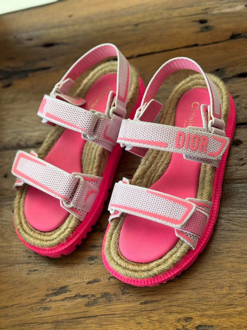 Christian Dior Pink D-Wander Sandals (Category: Flats & Sandals) located in Cabugao. Submitted by jezzarrogante_rmt (Listing ID 1464840827, Image 1). Description: - Brand: Dior - Color: Bright pink - Origin: Made in Italy - Features: Adjustable velcro straps with branding, chunky espadrille-style jute trim - Sole: Star tread pattern on durable rubber outsole - Fit: Comfortable open-toe design with secure heel strap.