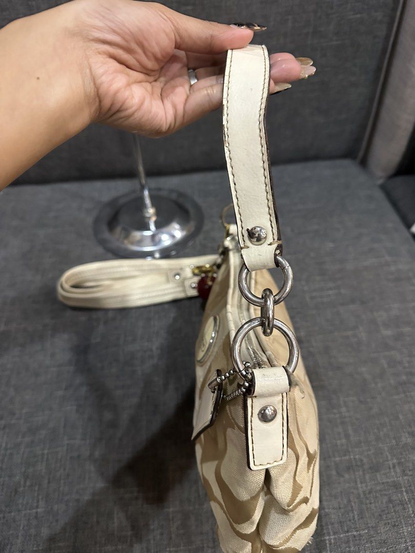 Coach (Category: Shoulder Bags) located in Manila. Submitted by goldenhorse-dafc (Listing ID 1464961345, Image 3). Description: - Brand: Coach - Style: Shoulder bag / Crossbody with detachable strap - Color/Pattern: Classic beige signature monogram canvas with white leather trim - Special Feature: Adorable red cherry charm included - Condition: 7/10 pre-loved condition (note: visible wear/cracking on the edges of the white leather strap as shown 