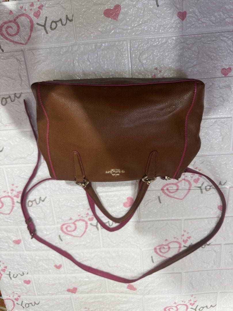 Coach Brown Leather Handbag with Pink Trim (Category: Luxury Bags & Wallets) located in Manila. Submitted by wildbear.e10374 (Listing ID 1464806010, Image 2). Description: Coach leather handbag in brown with vibrant pink trim and piping details. Gold-toned hardware and Coach logo stamped on the front. Dual top handles plus a detachable shoulder strap included. Multiple interior compartments lined in pink fabric with zipper pockets. Structured bas