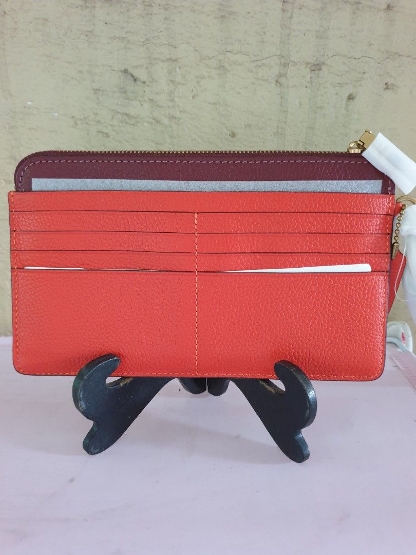 Coach Colorblock L-Zip Wristlet Red Orange Multi (Category: Wallets & Card holders) located in Las Pinas. Submitted by anggesmart (Listing ID 1464868727, Image 2). Description: - Brand: Coach - Style Number: C8569 - Color: Red orange multi with dark burgundy trim - Material: Textured leather with gold-tone hardware - Features: Signature C logo, top zip closure, attached wrist strap, exterior card slots, and interior fabric lining with Coach creed