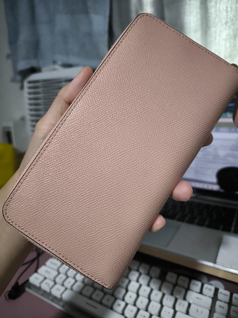 Coach Pink Leather Zip Around Wallet (Category: Wallets & Card holders) located in Taytay. Submitted by misspol (Listing ID 1464967176, Image 2). Description: - Authentic Coach leather wallet in a chic pink shade - Secure zip-around closure with smooth-running zipper - Exterior front slip pocket accented with the iconic silver Coach logo - Interior features multiple card slots and full-length bill compartments - Convenient middle zippered coin po