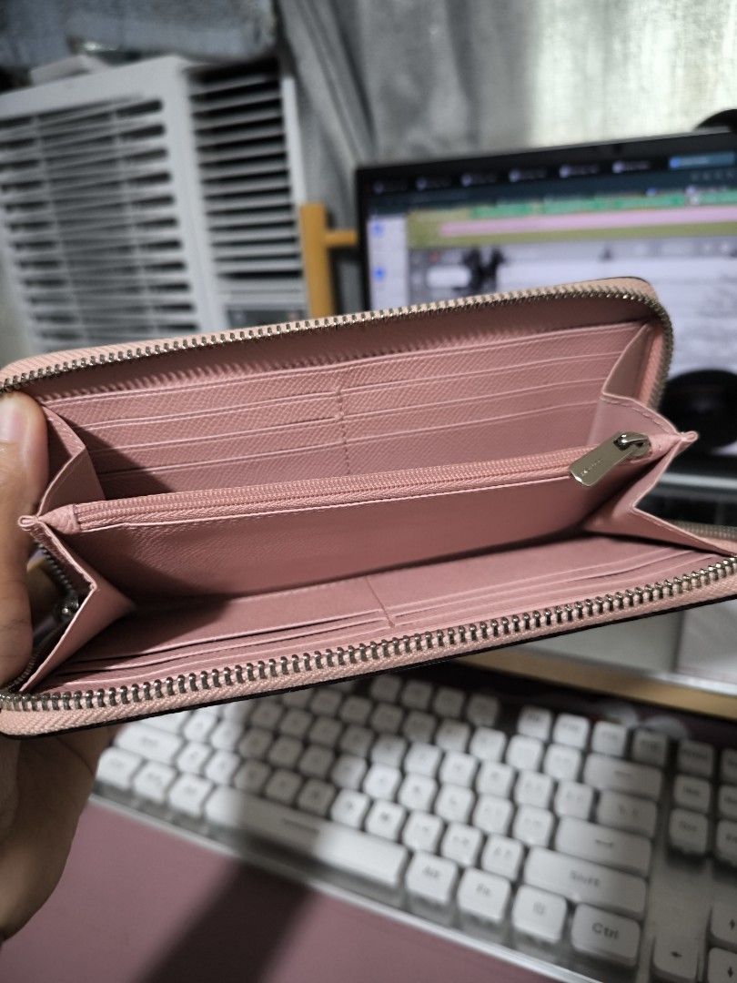 Coach Pink Leather Zip Around Wallet (Category: Wallets & Card holders) located in Taytay. Submitted by misspol (Listing ID 1464967176, Image 3). Description: - Authentic Coach leather wallet in a chic pink shade - Secure zip-around closure with smooth-running zipper - Exterior front slip pocket accented with the iconic silver Coach logo - Interior features multiple card slots and full-length bill compartments - Convenient middle zippered coin po