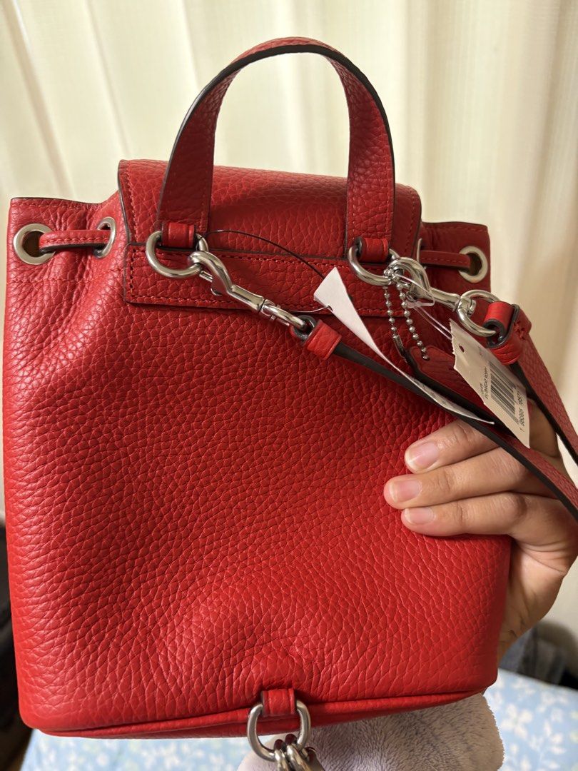 Coach Red Leather Mini Backpack (Category: Luxury Bags & Wallets) located in Muntinlupa City. Submitted by koi_143 (Listing ID 1464845719, Image 2). Description: - Brand: Coach from Japan - Material: Genuine red pebble leather - Hardware: Silver-tone with chic turnlock and buckle front details - Closure: Secure drawstring underneath the front flap - Versatility: Features a top handle and convertible back straps - Condition: Brand new - Size: Comp