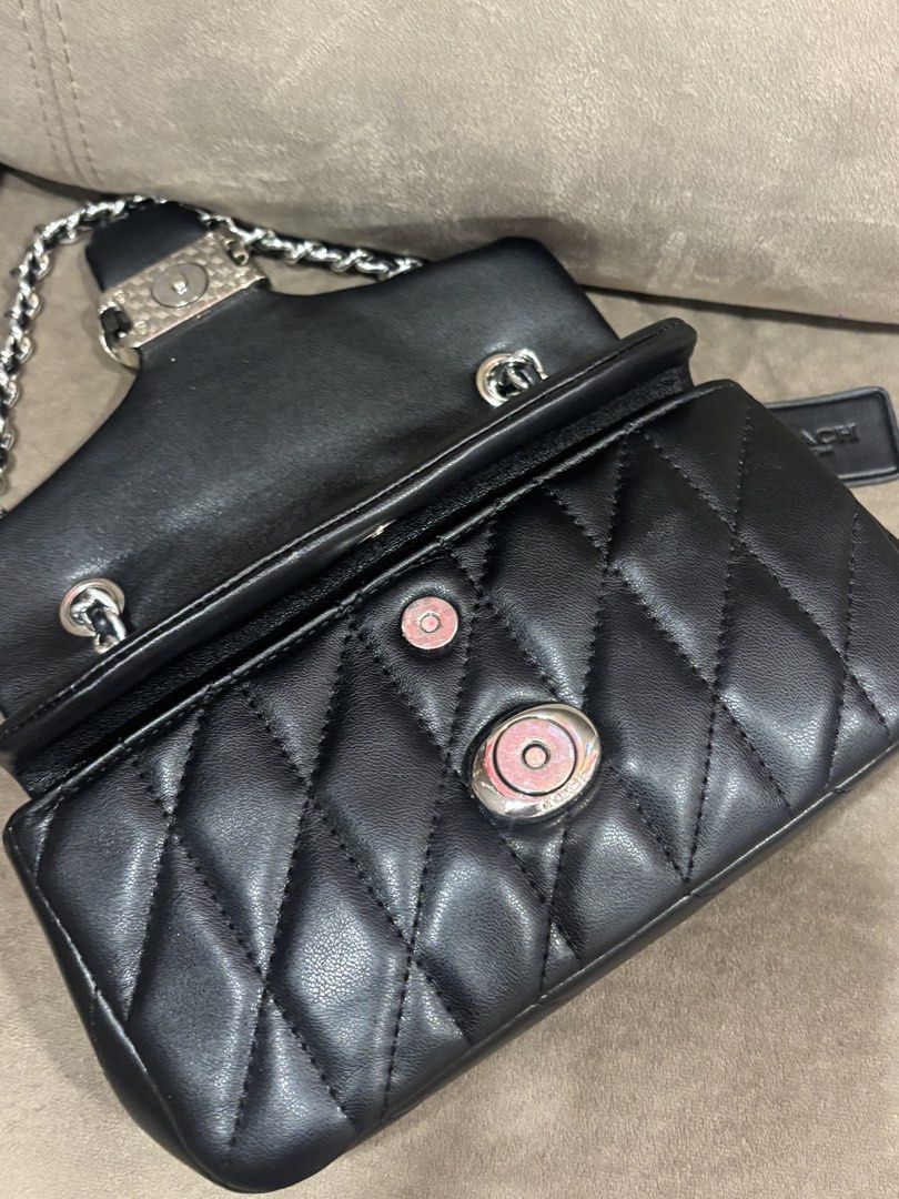 Coach Tabby 20 Quilted Black Leather Shoulder Bag (Category: Luxury Bags & Wallets) located in Andop. Submitted by pinkmatcha0715 (Listing ID 1464962593, Image 3). Description: - Coach shoulder bag in black quilted leather - Silver-tone chain straps and hardware - Signature front flap with turnlock closure - Fabric-lined interior featuring a convenient center zip compartment - Includes original black leather hangtag - Impeccable, well-maintained 