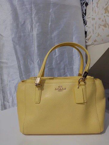 Coach Yellow Leather Handbag Tote (Category: Cross-body Bags) located in Quezon City. Submitted by luxuriesbymichiika (Listing ID 1464945243, Image 1). Description: - Brand: Coach - Color: Bright yellow - Material: Structured leather - Hardware: Gold-tone with matching hangtag - Handles: Double top handles with structured base - Interior: Multiple compartments - Condition: Clean exterior and stitching throughout - Style: Great daily carryall tote
