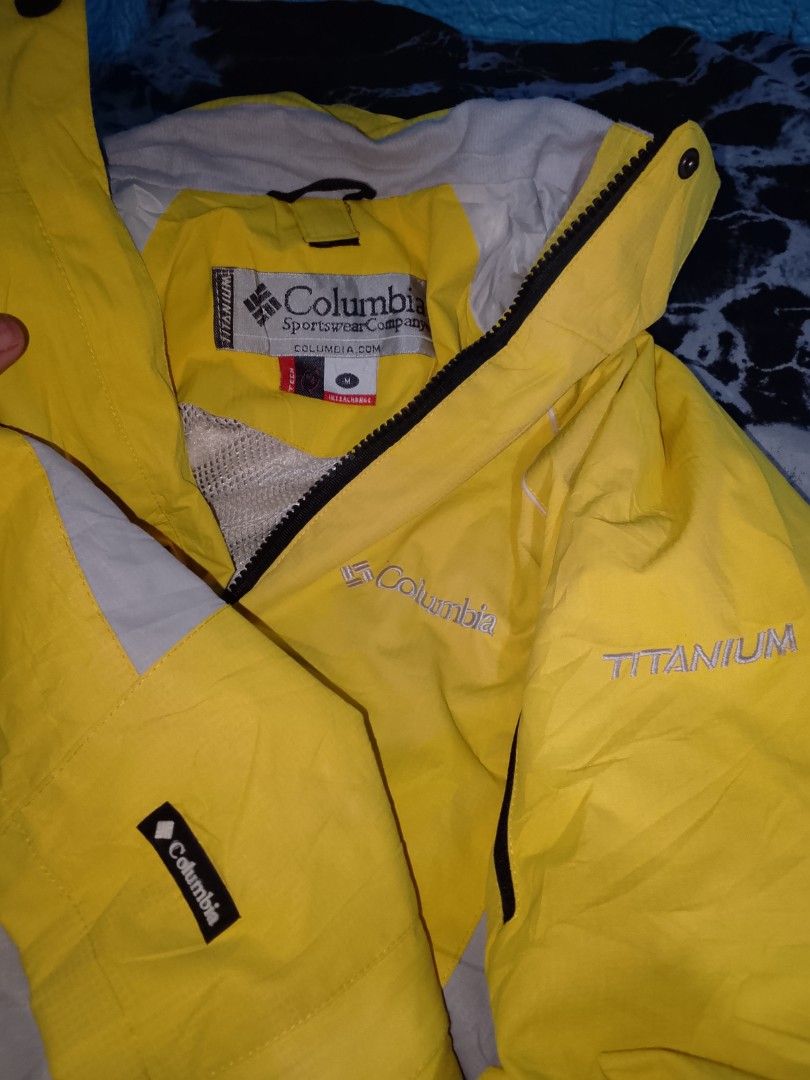 Columbia Titanium Yellow Outdoor Jacket Size M (Category: Coats, Jackets and Outerwear) located in Las Pinas. Submitted by solisjethr46316 (Listing ID 1464930760, Image 2). Description: - Brand: Columbia Titanium - Color: Bright yellow with grey side panels - Size: M - Features: Front and sleeve zip pockets, breathable mesh lining, high collar with snap button closure - Details: Adjustable cuffs, embroidered chest logo, Titanium sleeve text, and 