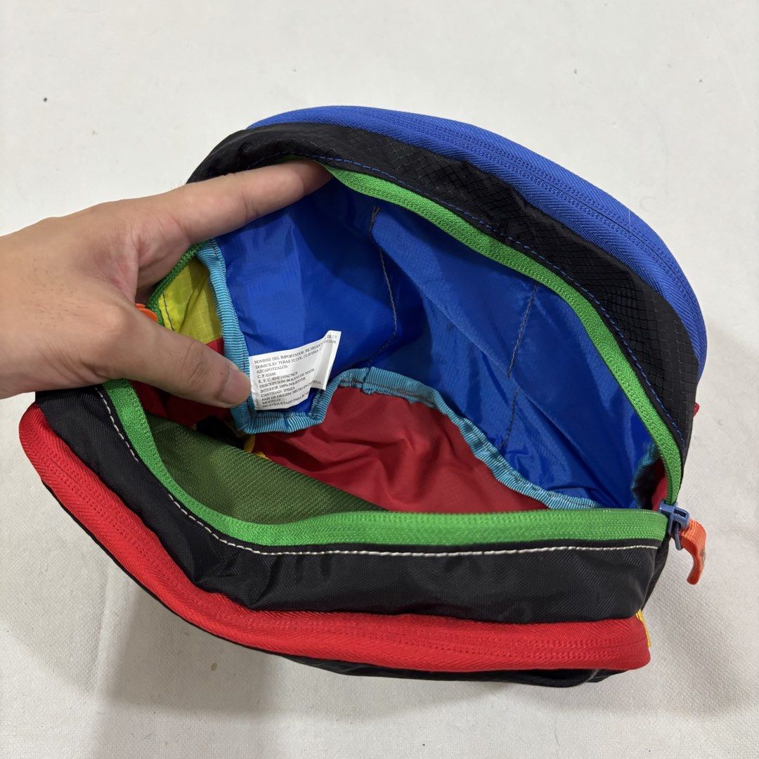 Cotopaxi multi-compartment colourful dopp kit toiletry bag (Category: Belt bags, Clutches and Pouches) located in Cavite. Submitted by itsayaaa (Listing ID 1464836896, Image 2). Description: - Cotopaxi toiletry bag in a vibrant color-block design (black, red, green, blue, yellow) - Durable ripstop nylon fabric built for travel and daily wear - Multiple zipped compartments inside and out for easy organization - Features a convenient side grab loop
