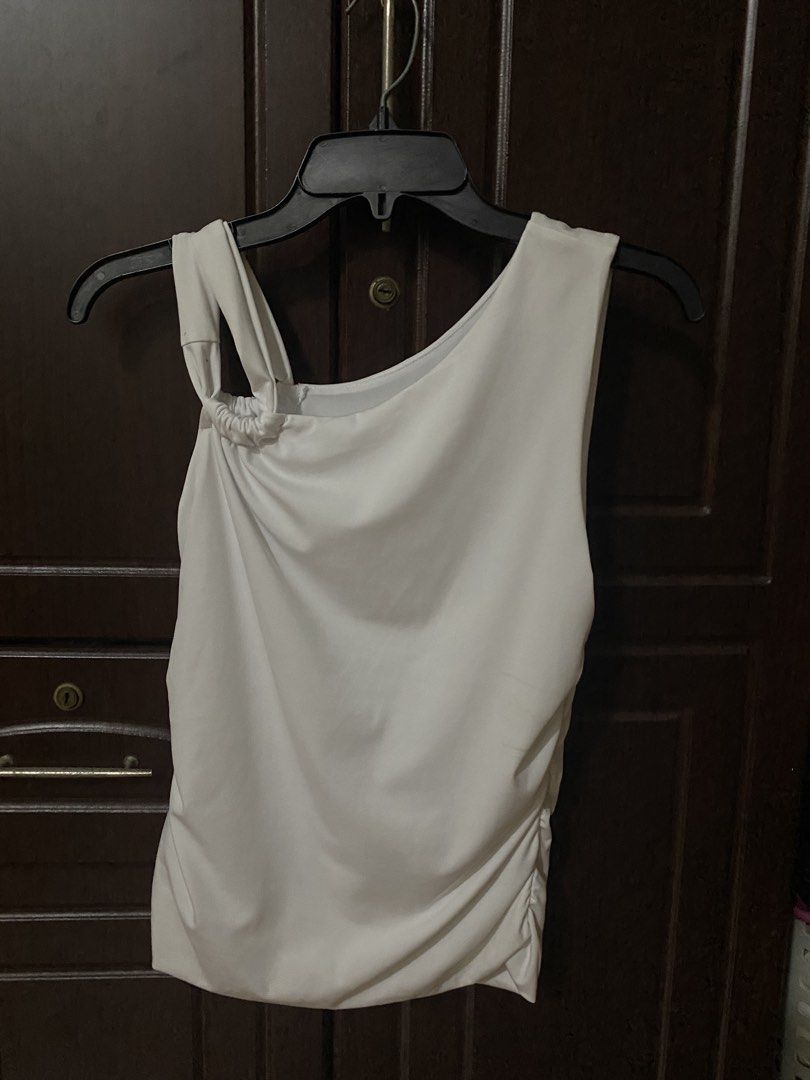 Cotton On Addison Twist Shoulder Top (Category: Sleeveless) located in Manila. Submitted by hiroknowsss (Listing ID 1464904661, Image 2). Description: - Brand: Cotton On - Size: L - Color: White - Design: One-shoulder with unique strap & cute side ruching - Fabric: Comfortable and stretchy - Style: Versatile basic, easy to dress up or down.