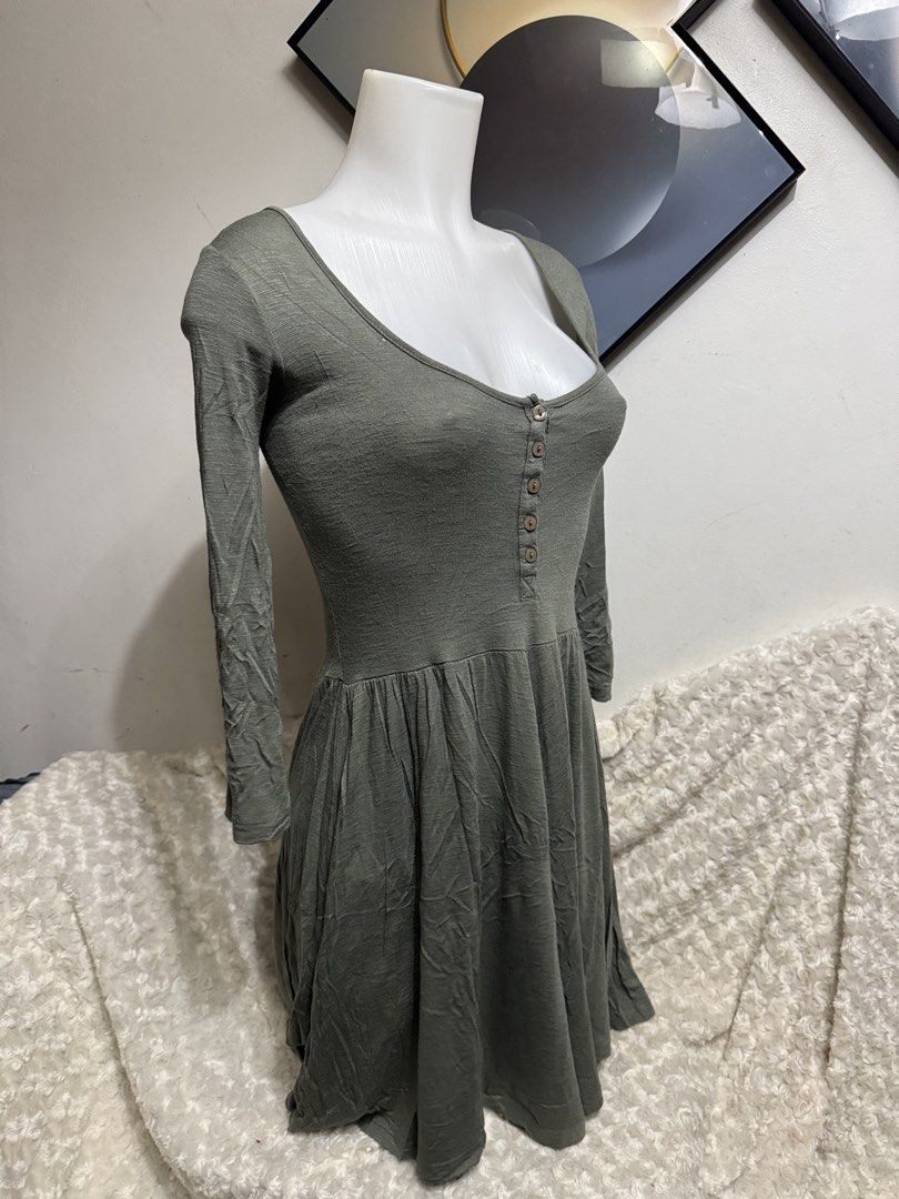 Cotton On Sage Green Button Front Dress Size S (Category: Dresses) located in Marikina City. Submitted by lorradel (Listing ID 1464904487, Image 2). Description: - Brand: Cotton On - Size: S but fits up to Large - Color: Sage Green - Design: Scoop neckline with brown front buttons, fitted bodice, and flared skirt - Sleeves: Long sleeves - Material: Soft, lightweight, and stretchy fabric - MAY HAVE some washable stains (hindi maiiwasan) needs wash