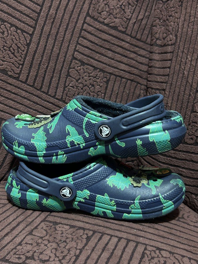Crocs Dinosaur Lined Clogs with Jibbitz Charms (Category: Babies & Kids Fashion) located in Binan City. Submitted by lehcarsmusthaves (Listing ID 1464948017, Image 3). Description: - Color & Design: Navy blue with an all-over green dinosaur print - Warmth: Cozy fuzzy lining inside, perfect for cooler days - Extras: Comes with fun dinosaur Jibbitz charms already attached - Fit: Easy slip-on design with a pivoting heel strap Free jibbits (has 2 lum