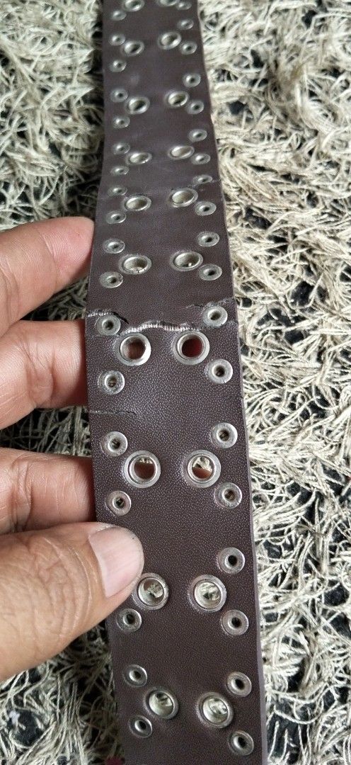 Dark Brown Grommet Studded Leather Belt (Category: Belts) located in Paranaque City. Submitted by michael-08 (Listing ID 1464782676, Image 3). Description: - Style: Punk rock aesthetic, dark brown leather belt - Hardware: Silver grommets, metal studs, and heavy metal double-prong buckle with aged silver finish - Dimensions: Roughly 1.5 inches wide - Condition: Sturdy construction with a small spot mark on the leather near the top buckle area - Fe