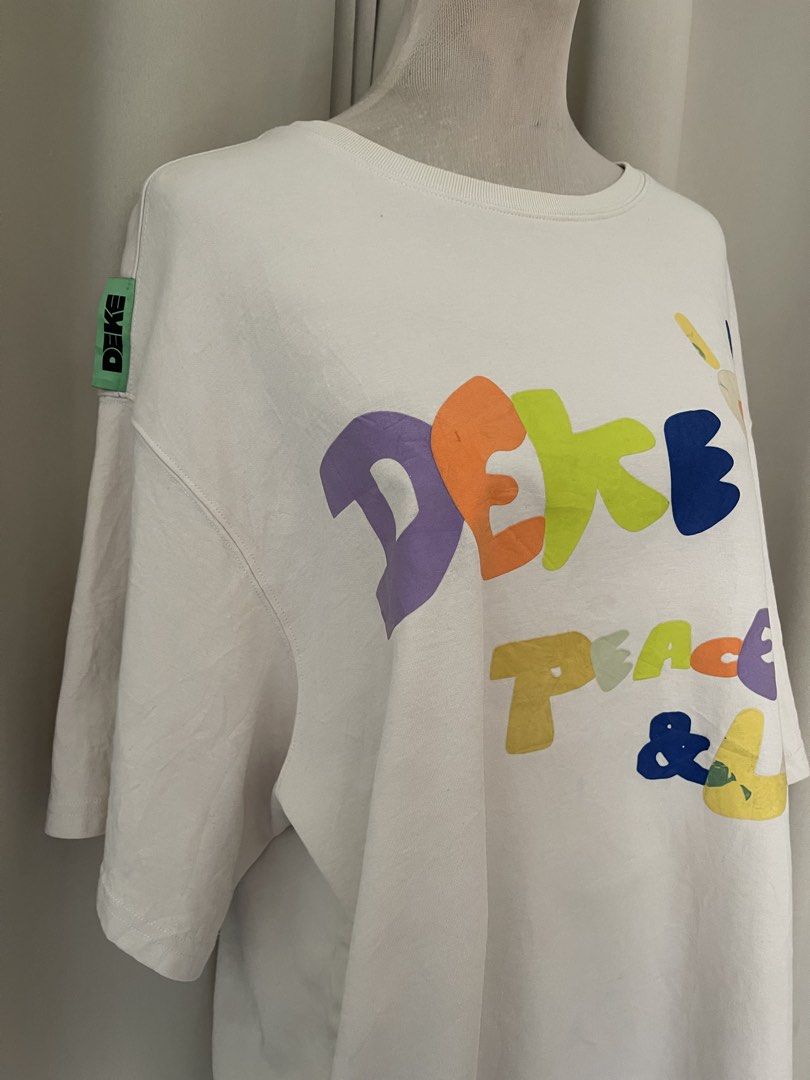 DEKE Oversized heavy cotton (Category: Tshirts & Polo Shirts ) located in Cainta. Submitted by zlove111 (Listing ID 1464808513, Image 3). Description: - Color: Cream with multicolored graphic - Design: 'PEACE & LOVE' playful lettering on front, small green logo tag on right sleeve - Fit: Oversized / relaxed fit, crew neck, short sleeves - Condition: Brand new / Excellent - Perfect to pair with your favorite denim or shorts for an effortless, casu