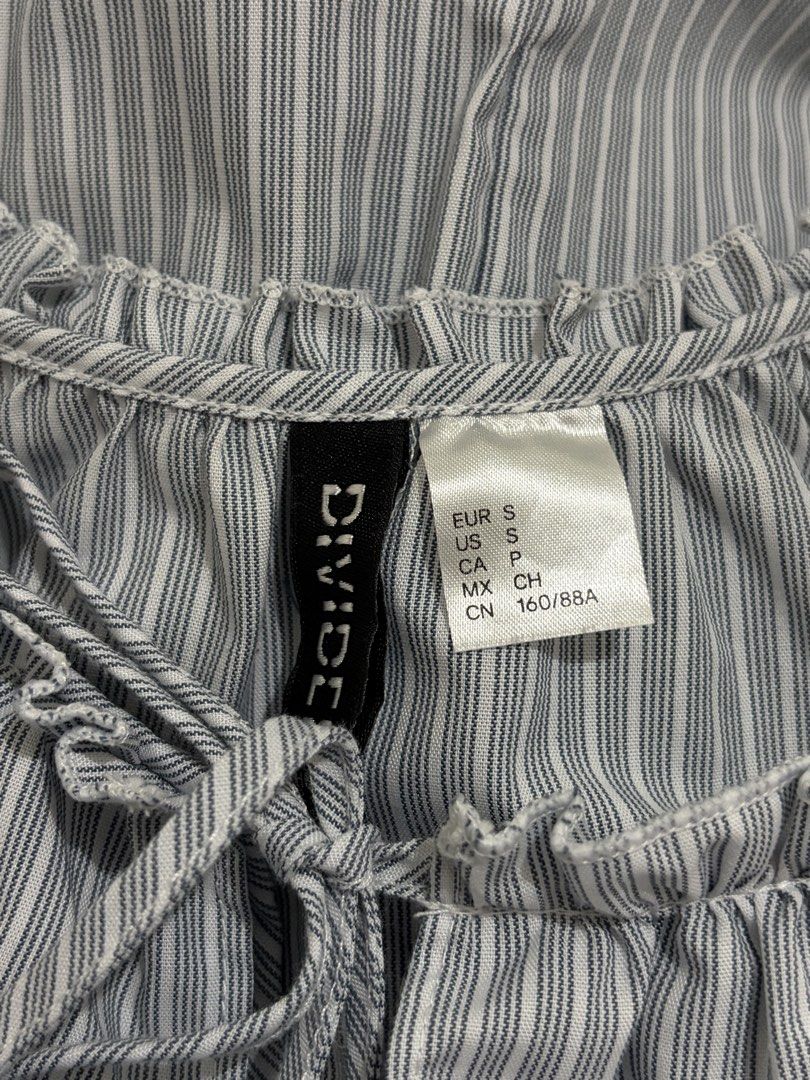 DIVIDED Blue and White Striped Ruffle Blouse (Category: Blouses) located in Cainta. Submitted by knarv__ (Listing ID 1464883771, Image 2). Description: DIVIDED blue & white striped blouse in size S. Features a cute ruffled collar with a drawstring tie and elastic ruffled cuffs. Lightweight, clean, and versatile for work or casual wear..