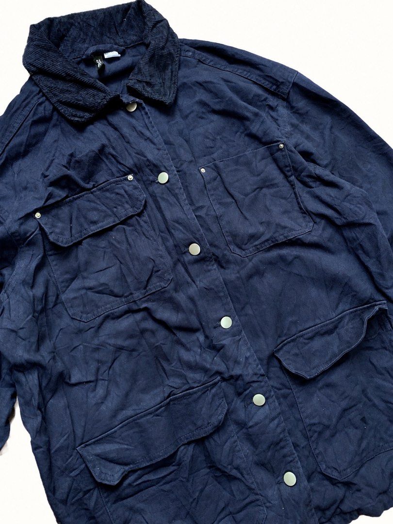 Divided Navy Blue Utility Jacket with Corduroy Collar (Category: Coats, Jackets and Outerwear) located in Zamboanga. Submitted by dayangjail94920 (Listing ID 1464857199, Image 3). Description: - Brand/Model: Divided utility jacket - Color: Navy blue with contrasting dark corduroy collar and cuffs - Closure: Snap button front - Pockets: Multiple utility pockets on chest and lower body - Fit: Relaxed fit with dropped shoulders - Material: Heavy cot