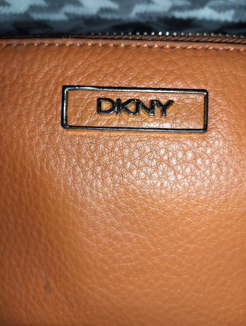 DKNY Orange Zip-Around Leather Wallet (Category: Wallets & Card holders) located in Caloocan City. Submitted by girlshopmcollection (Listing ID 1464870414, Image 2). Description: - Brand: DKNY - bright orange - Hardware: Gold-tone with metal front logo - Interior: Tan with multiple card slots, slip pockets, and central zippered coin compartment - Lining: Clean with repeating logo pattern - Closure: Smooth zip-around.