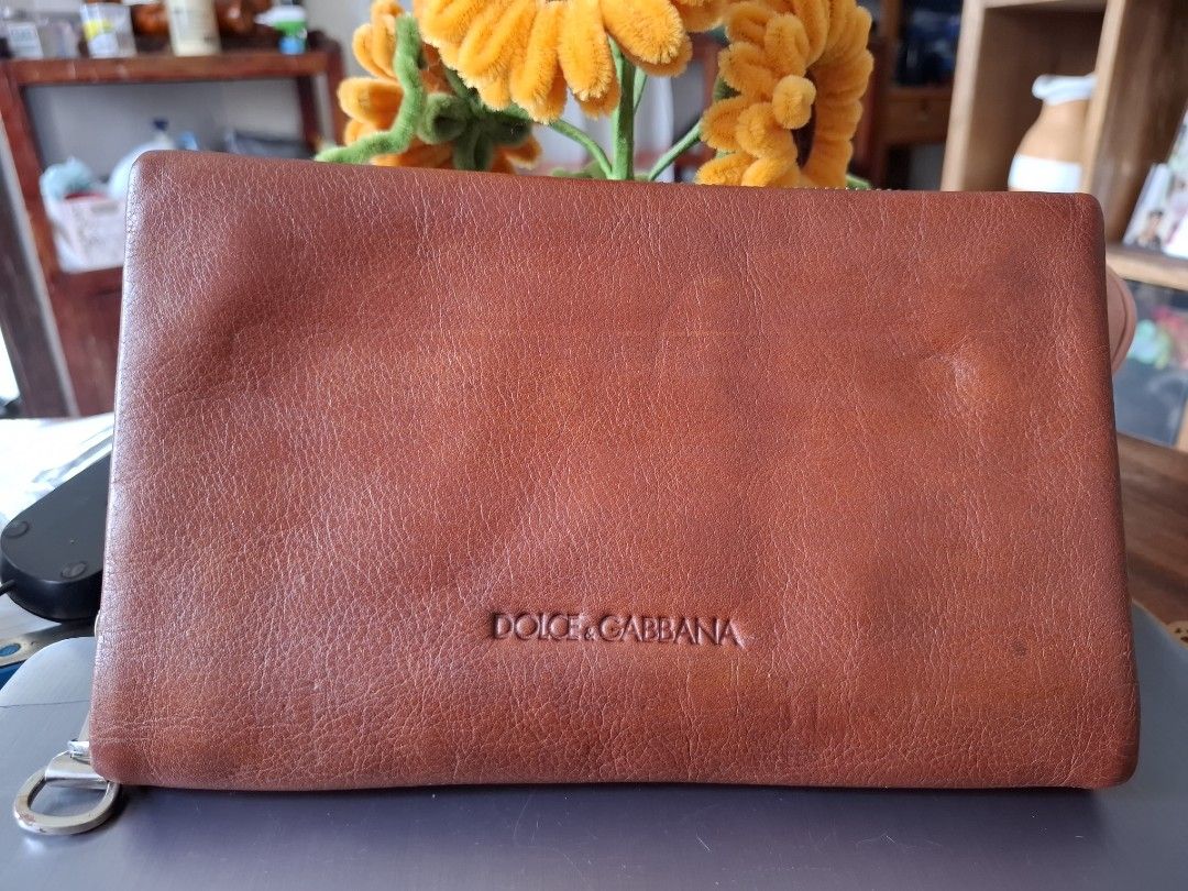 Dolce & Gabbana Brown Leather Wallet (Category: Luxury Bags & Wallets) located in Libon. Submitted by jaladzarmi80045 (Listing ID 1464795447, Image 1). Description: - Authentic Dolce & Gabbana brown leather wallet, Made in Italy - Secure closure: Snap button flap and back zip pocket - Storage: Multiple card slots, clear ID window, and a dedicated coin pouch - Condition: Minor surface wear from previous use, still sturdy and fully functional - Per