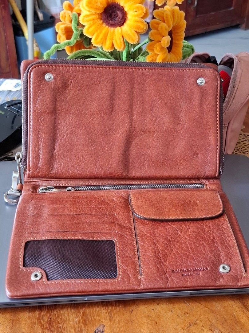 Dolce & Gabbana Brown Leather Wallet (Category: Luxury Bags & Wallets) located in Libon. Submitted by jaladzarmi80045 (Listing ID 1464795447, Image 3). Description: - Authentic Dolce & Gabbana brown leather wallet, Made in Italy - Secure closure: Snap button flap and back zip pocket - Storage: Multiple card slots, clear ID window, and a dedicated coin pouch - Condition: Minor surface wear from previous use, still sturdy and fully functional - Per