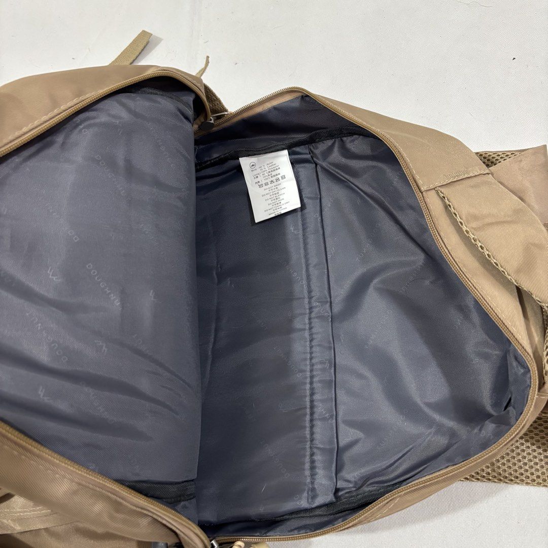 Doughnut Outdoor Adventure Backpack Khaki (Category: Backpacks) located in Cavite. Submitted by itsayaaa (Listing ID 1464839030, Image 3). Description: - Brand/Series: Doughnut Outdoor Adventure Series - Color: Khaki with grey branded inner lining - Material: Durable nylon and leather - Storage: Multiple front zipper pockets and internal slip pocket - Features: Secure buckle straps at the bottom and adjustable mesh shoulder straps - Condition: Cl