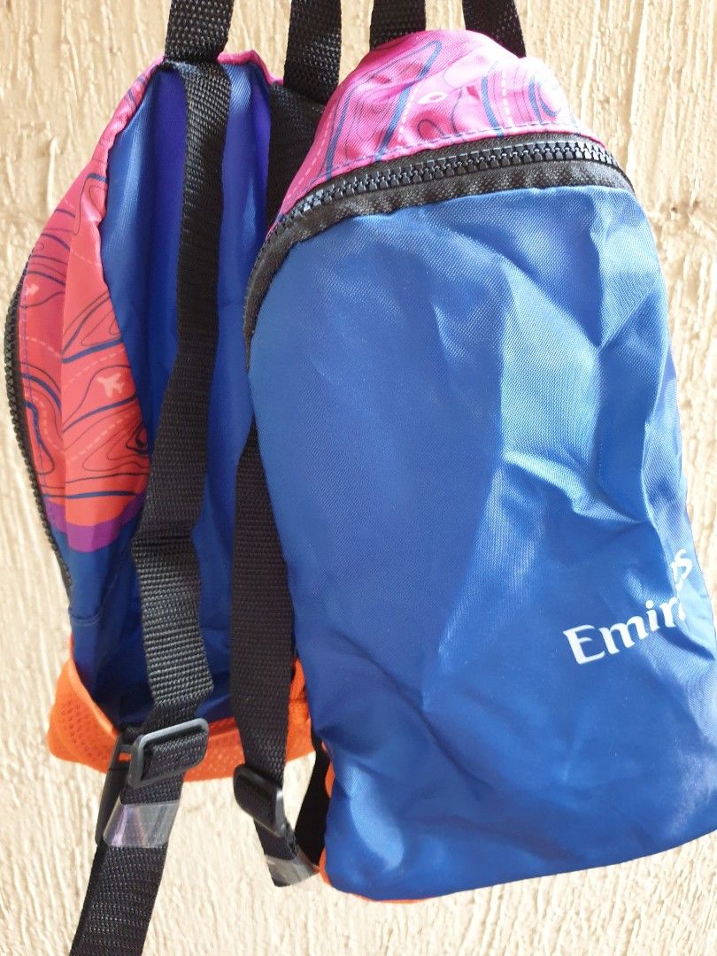 Emirates Airline Multicolored Foldable Travel Backpack (Category: Backpacks) located in Las Pinas. Submitted by anggesmart (Listing ID 1464867738, Image 1). Description: - Official Emirates airline merchandise - Packable design: folds into its own zipped pouch - Eye-catching pink & purple topographic map pattern with airplane icons - Features adjustable black shoulder straps and bright orange side mesh accents - Lightweight and ideal for travel, 