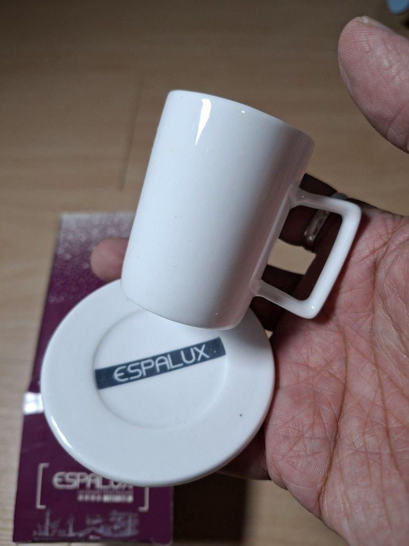 Espalux White Ceramic Espresso Cup And Saucer Set (Category: Coffee & Tea Tableware) located in Baguio. Submitted by restyrille77846 (Listing ID 1464891915, Image 2). Description: - Brand: Espalux - Item: White ceramic espresso cup with matching saucer - Design feature: Modern square handle detail - Condition: Brand new, never used, pristine condition - Packaging: Comes in original purple branded box - Style: Classic minimalist design.