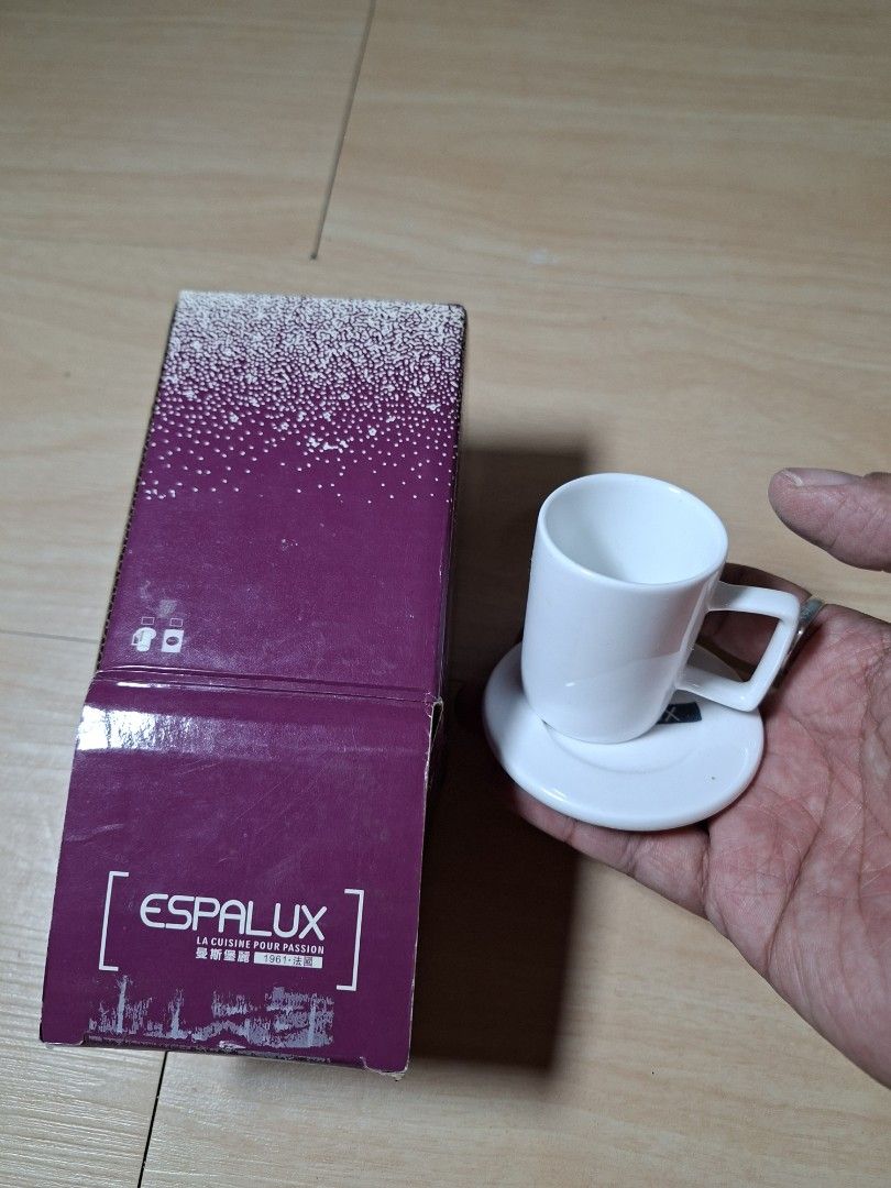 Espalux White Ceramic Espresso Cup And Saucer Set (Category: Coffee & Tea Tableware) located in Baguio. Submitted by restyrille77846 (Listing ID 1464891915, Image 1). Description: - Brand: Espalux - Item: White ceramic espresso cup with matching saucer - Design feature: Modern square handle detail - Condition: Brand new, never used, pristine condition - Packaging: Comes in original purple branded box - Style: Classic minimalist design.