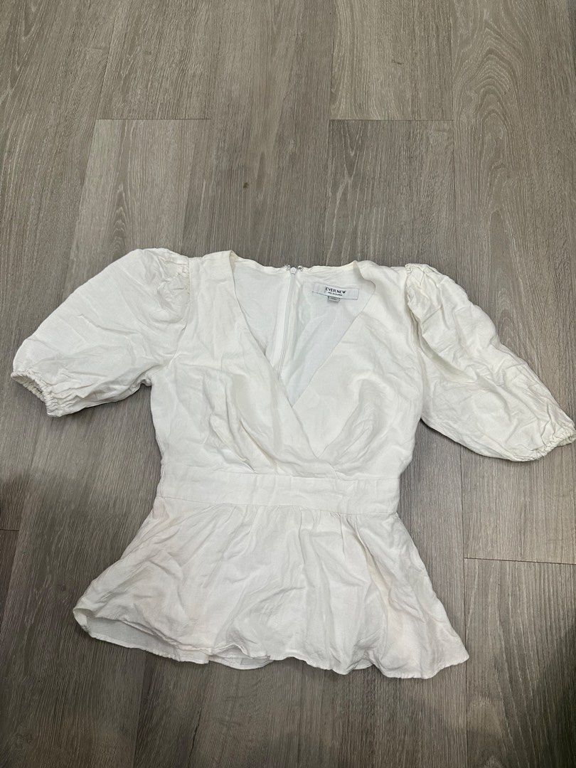 Ever New White Puff Sleeve Peplum Top (Category: Blouses) located in Manila. Submitted by itsarah (Listing ID 1464835327, Image 1). Description: Ever New Melbourne white top in AUS size 4, EUR 32, USA 0. Features short puff sleeves with elastic cuffs and a fitted peplum waist. Deep V-neckline wrap front style. Zip closure at the back. Clean white fabric, great for casual outings or dressing up for dinner..