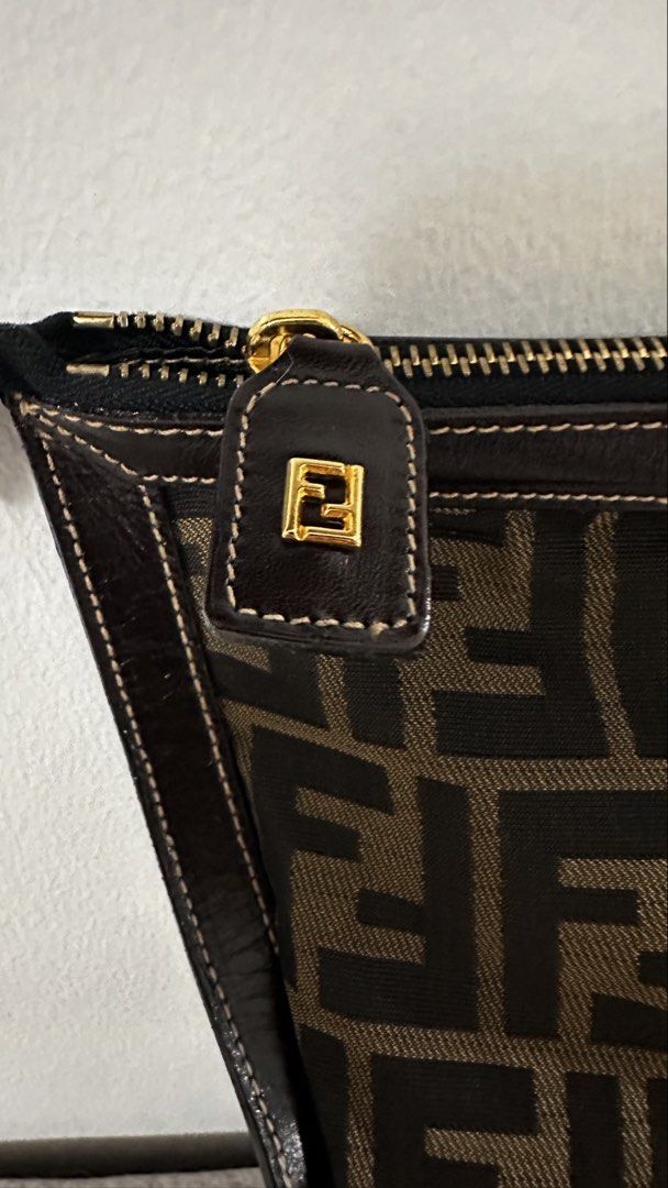 Fendi Zucca Canvas Pouch Clutch (Category: Luxury Bags & Wallets) located in Quezon City. Submitted by ror-y (Listing ID 1464910357, Image 2). Description: Fendi Zucca Canvas Pouch distinguished by its iconic brown-and-black FF monogram canvas and dark leather corner framing. Dimensions: 13x11.5 inches .