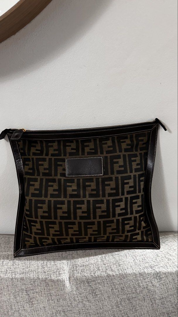 Fendi Zucca Canvas Pouch Clutch (Category: Luxury Bags & Wallets) located in Quezon City. Submitted by ror-y (Listing ID 1464910357, Image 1). Description: Fendi Zucca Canvas Pouch distinguished by its iconic brown-and-black FF monogram canvas and dark leather corner framing. Dimensions: 13x11.5 inches .