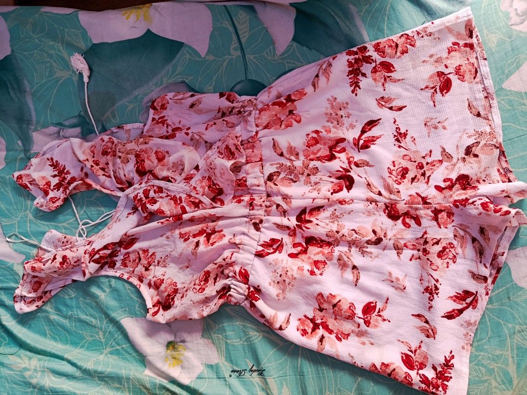 Floral Print Ruffle Romper with Tie Straps (Category: Rompers) located in Manila. Submitted by jzministore (Listing ID 1464781534, Image 1). Description: - Color/Pattern: White with red and pink floral print - Design: Ruffled overlay on front and back - Straps: Thin straps with cute tassel ends - Waist: Comfy elastic waistband for easy fit - Material: Lightweight fabric, ideal for warm weather - Condition: Excellent/Like new - MOP: GCash, BPI, or