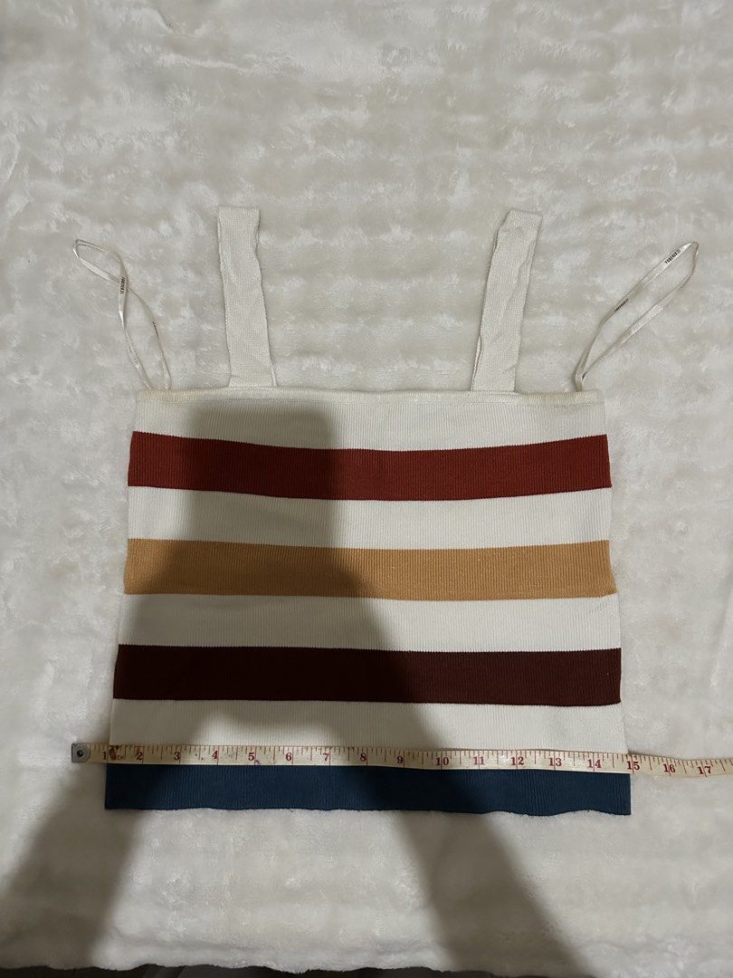Forever 21 Multi-striped Knit Tank Top (Category: Sleeveless) located in Cavite. Submitted by thebarchives (Listing ID 1464886193, Image 2). Description: - Brand: Forever 21 - Style: Knit tank top with square neckline and straps - Pattern: Retro horizontal stripes (rust, mustard yellow, dark brown, white, navy blue) - Texture: Ribbed throughout - Condition: Good overall, with minor yellowing near the right armhole and strap base (just need to was