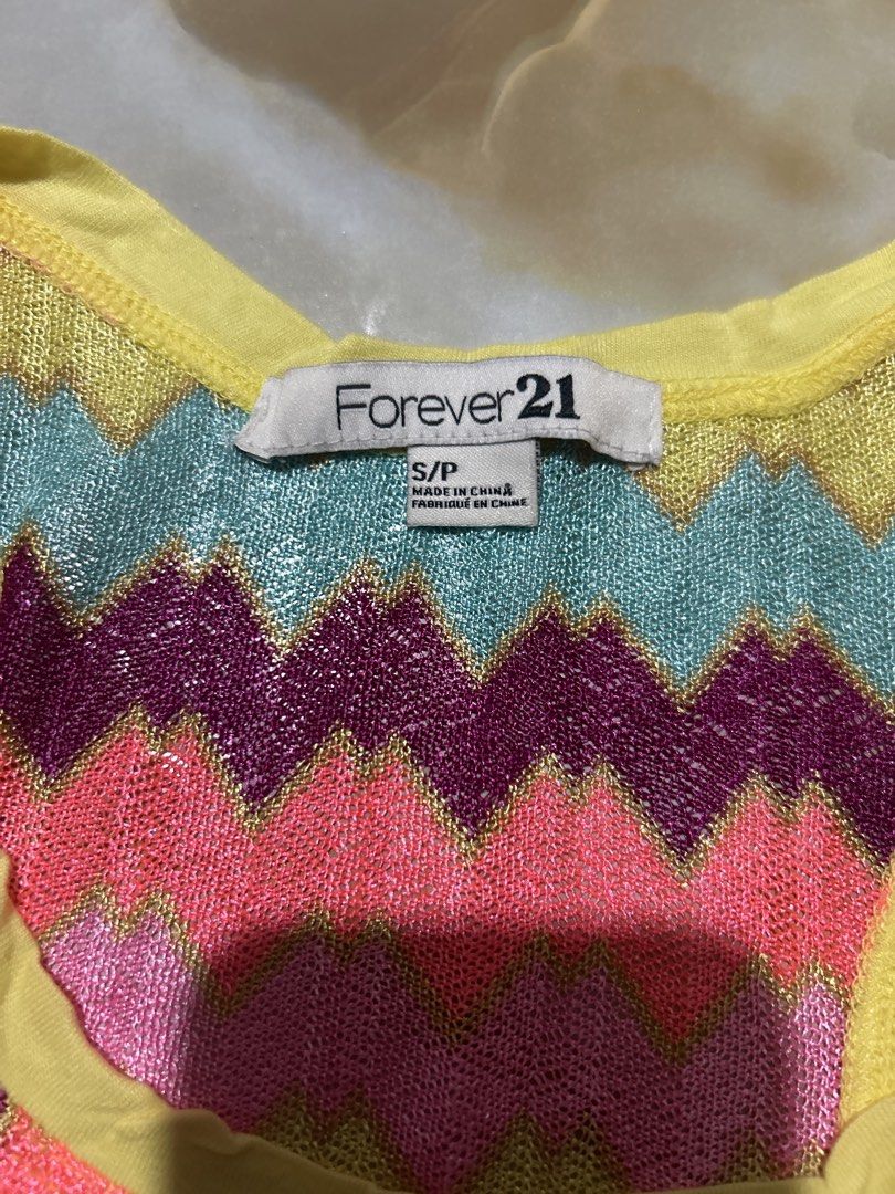 Forever 21 Zigzag Metallic Tank Top Size S (Category: Sleeveless) located in Lal-Lo. Submitted by pureearth_8c747c (Listing ID 1464785761, Image 2). Description: - Brand: Forever 21 - Size: Small - Design: Vibrant multicolored zigzag pattern with a shimmery metallic finish - Details: Contrast yellow trim along the scoop neckline and armholes - Material: 100% polyester (Hand wash only) - Fit: Lightweight, sleeveless, and great for warm weather or 