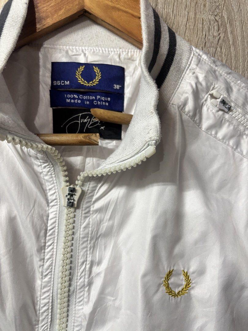 Fred Perry White Bomber Jacket Size 38 (Category: Coats, Jackets and Outerwear) located in Baguio. Submitted by gab_thrift (Listing ID 1464877230, Image 2). Description: - Brand: Fred Perry - Item: White bomber jacket with full zip closure - Size: 38 inches / 96cm - Details: Striped ribbed collar, cuffs, and hem; functional side zippered pockets - Branding: Iconic gold laurel wreath embroidered on the chest - Material: Made in China with 100% cot