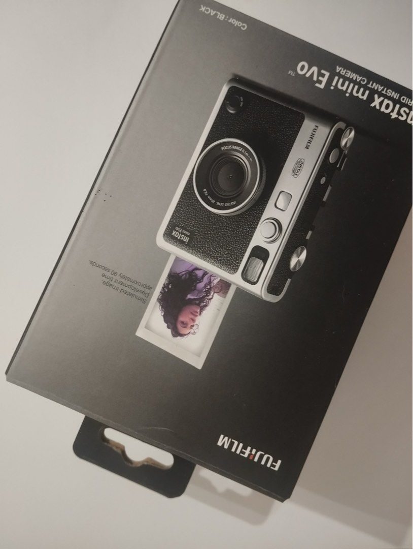Fujifilm Instax Mini Evo Hybrid Instant Camera (Category: Cameras) located in Tagoloan. Submitted by kethhh (Listing ID 1464797224, Image 3). Description: - Model: Fujifilm Instax Mini Evo (Black & Silver) - Features: Hybrid digital camera with built-in Instax Mini printer and rear LCD screen - Controls: Classic manual dials and levers on top - Inclusions: Original retail box and body as pictured - Condition: Excellent, great for instant photogra