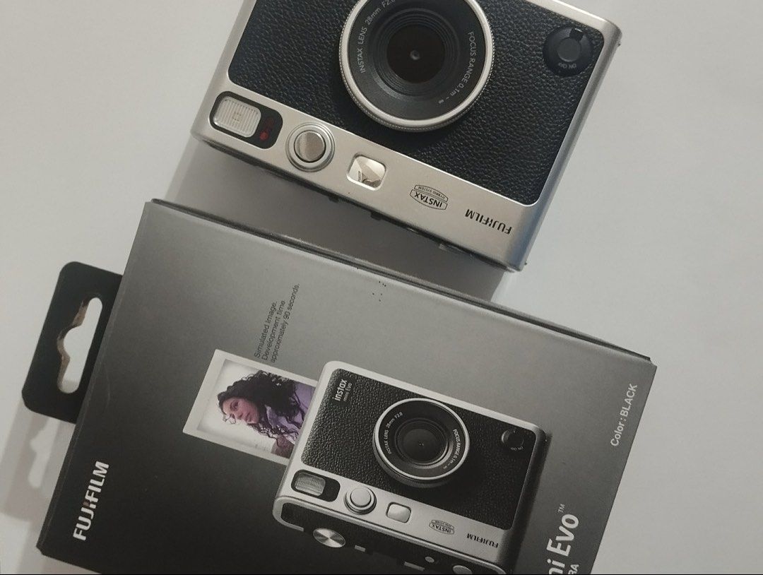 Fujifilm Instax Mini Evo Hybrid Instant Camera (Category: Cameras) located in Tagoloan. Submitted by kethhh (Listing ID 1464797224, Image 1). Description: - Model: Fujifilm Instax Mini Evo (Black & Silver) - Features: Hybrid digital camera with built-in Instax Mini printer and rear LCD screen - Controls: Classic manual dials and levers on top - Inclusions: Original retail box and body as pictured - Condition: Excellent, great for instant photogra