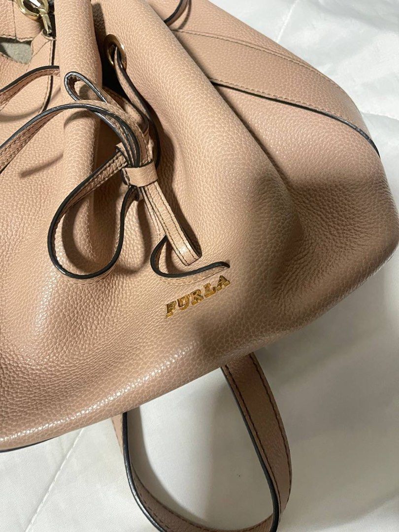 Furla Pink Leather Bucket Bag Backpack Convertible (Category: Luxury Bags & Wallets) located in Paranaque City. Submitted by prelovedfrompat (Listing ID 1464916144, Image 3). Description: - Authentic Furla pink leather bucket bag - Premium textured pebbled leather with gold-tone hardware - Secure drawstring closure - Soft suede interior lining with a handy slip pocket - Convertible straps for shoulder bag or backpack styling - Versatile blush neu