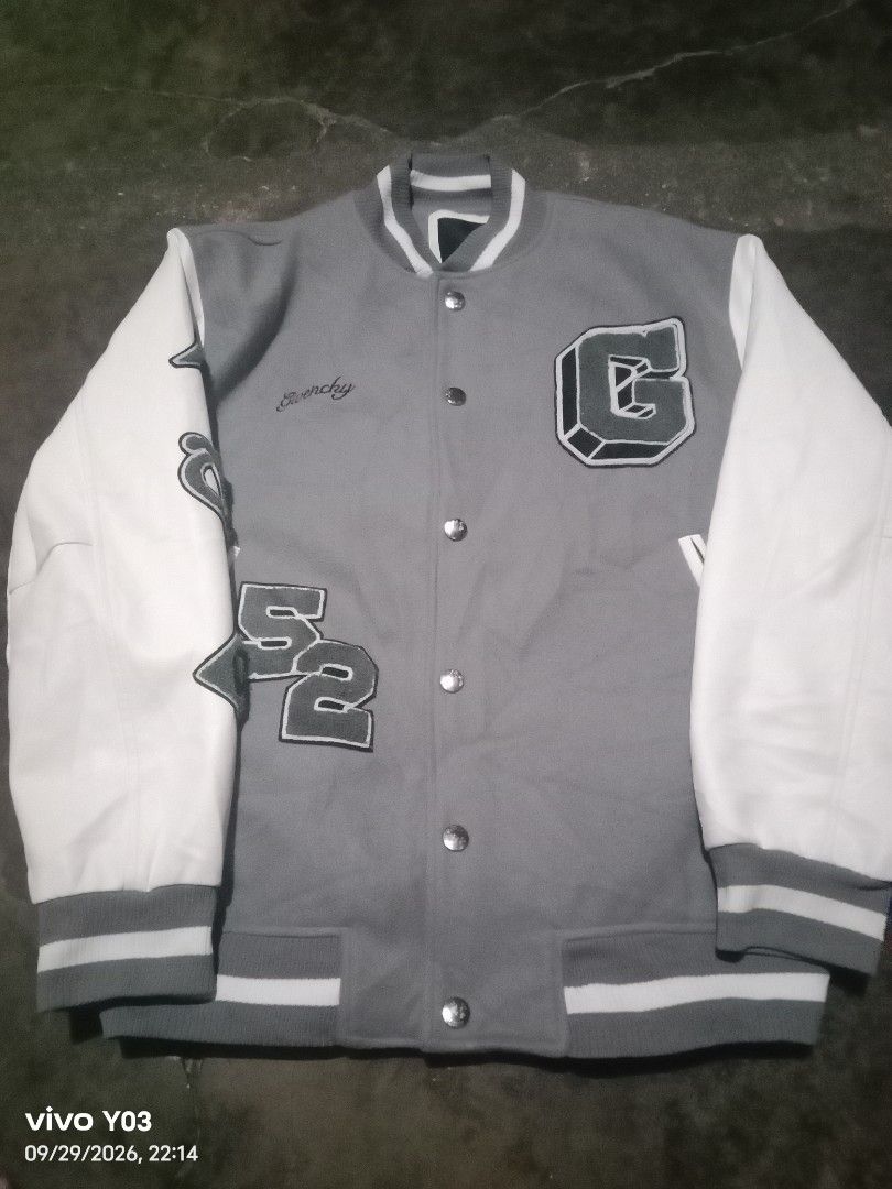 Givenchy Grey and White Varsity Jacket (Category: Coats, Jackets and Outerwear) located in Cabuyao City. Submitted by blake657 (Listing ID 1464908029, Image 1). Description: - Style: Grey and white varsity jacket - Brand detailing: Givenchy branding on the front - Accents: Large letter patches on the chest, sleeves, and back - Design: Contrasting white sleeves with button-down front - Trim: Ribbed cuffs and hem with striped detailing.