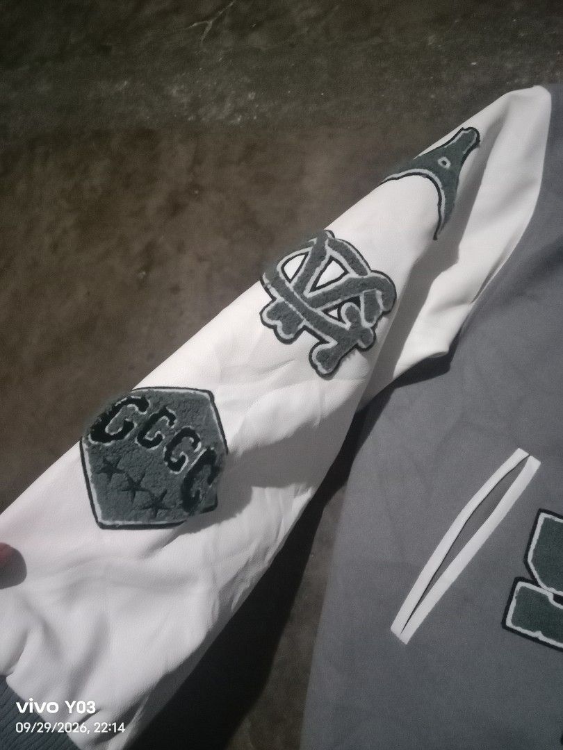 Givenchy Grey and White Varsity Jacket (Category: Coats, Jackets and Outerwear) located in Cabuyao City. Submitted by blake657 (Listing ID 1464908029, Image 2). Description: - Style: Grey and white varsity jacket - Brand detailing: Givenchy branding on the front - Accents: Large letter patches on the chest, sleeves, and back - Design: Contrasting white sleeves with button-down front - Trim: Ribbed cuffs and hem with striped detailing.