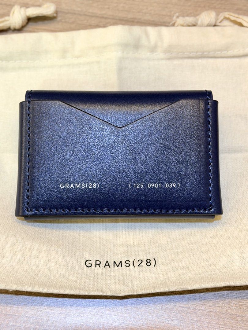 GRAMS(28) 125 Leather Card Case - Dark Blue (Category: Wallets & Card Holders) located in Pasig City. Submitted by theclosetcasemanila (Listing ID 1464927478, Image 1). Description: - Brand: GRAMS(28) - Material: Premium Genuine Italian Leather in blue color - Design: Envelope-style front flap with neat white stitching - Details: Stamped branding and unique ID number on the front - Interior: Lined with textured fabric for a refined finish - Inclu