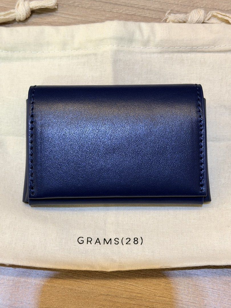 GRAMS(28) 125 Leather Card Case - Dark Blue (Category: Wallets & Card Holders) located in Pasig City. Submitted by theclosetcasemanila (Listing ID 1464927478, Image 2). Description: - Brand: GRAMS(28) - Material: Premium Genuine Italian Leather in blue color - Design: Envelope-style front flap with neat white stitching - Details: Stamped branding and unique ID number on the front - Interior: Lined with textured fabric for a refined finish - Inclu