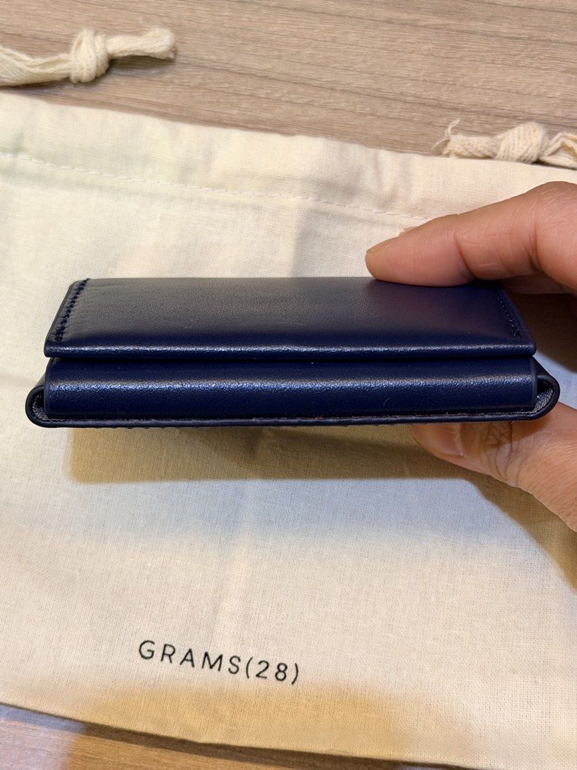 GRAMS(28) 125 Leather Card Case - Dark Blue (Category: Wallets & Card Holders) located in Pasig City. Submitted by theclosetcasemanila (Listing ID 1464927478, Image 3). Description: - Brand: GRAMS(28) - Material: Premium Genuine Italian Leather in blue color - Design: Envelope-style front flap with neat white stitching - Details: Stamped branding and unique ID number on the front - Interior: Lined with textured fabric for a refined finish - Inclu