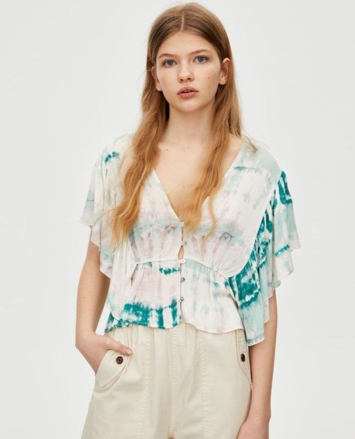Green and white tie-dye crop blouse from Pull&Bear (Category: Blouses) located in Cabanatuan. Submitted by miss.maia (Listing ID 1464947649, Image 1). Description: The image shows a green and white tie-dye crop blouse from Pull&Bear featuring a deep V-neck, front button closure, and short ruffled sleeves..