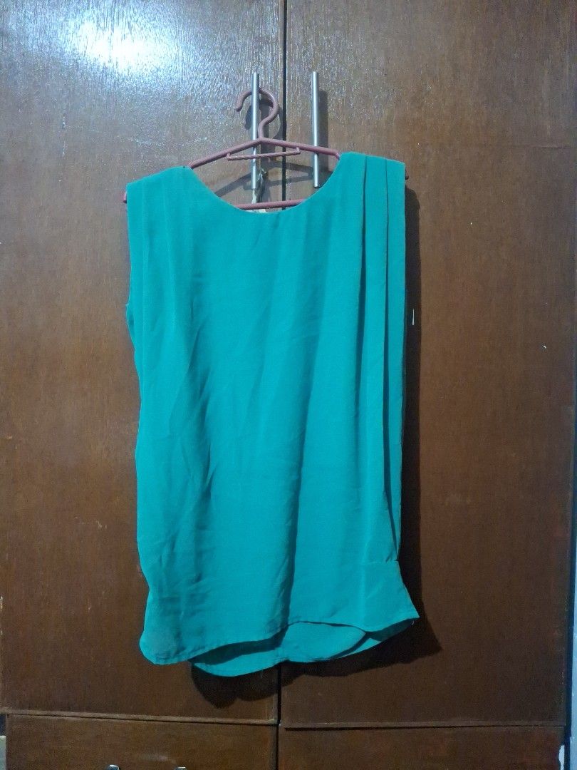 Green sleeveless pleated blouse top (Category: Sleeveless) located in Quezon City. Submitted by 042361 (Listing ID 1464839355, Image 2). Description: - Color: Bright green - Style: Sleeveless top with pleated neckline detail - Fabric: Lightweight, flowy chiffon-like material - Versatility: Great for casual days or layering under blazers - Fit: Hangs nicely, solid color all over.