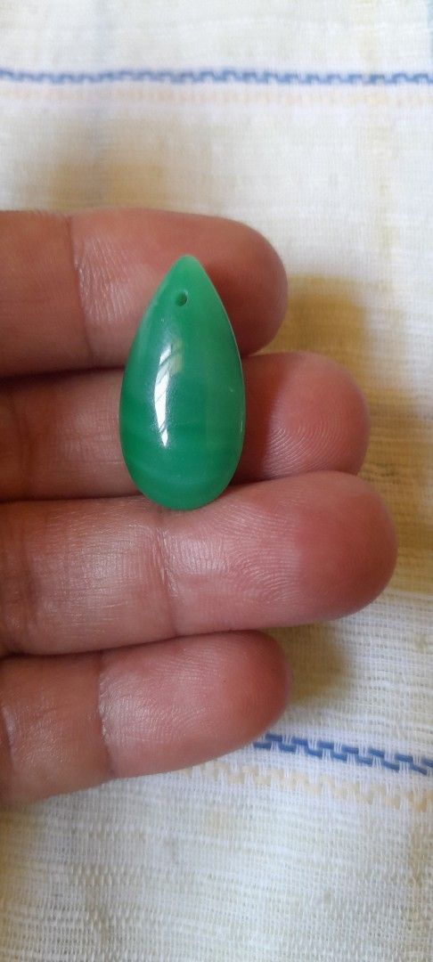 Green tear drop jade pendant (Category: Necklaces) located in Bocaue. Submitted by marajapansurplus (Listing ID 1464773993, Image 1). Description: - Stunning green teardrop stone pendant - Pre-drilled hole near the top for easy hanging on a cord or chain - Smooth, polished finish showcasing unique natural banding and color variations - Lightweight design that is comfortable to wear - Ideal for DIY jewelry making and custom accessories.