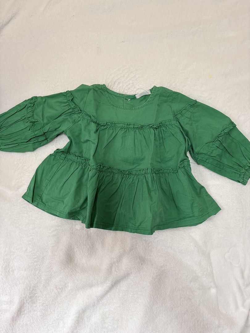 Green Tiered Ruffle Long Sleeve Blouse (Category: Babies & Kids Fashion) located in Cabuyao City. Submitted by mhd.i (Listing ID 1464968400, Image 1). Description: - Color: Bright green - Design: Three-layer gathered tiered design with shoulder ruffles - Sleeves: Long sleeves with elastic ruffled cuffs - Neckline: Round neckline - Fit: Relaxed fit through the body - Fabric: Lightweight and comfortable - Styling: Easy to pair with jeans or skirts.
