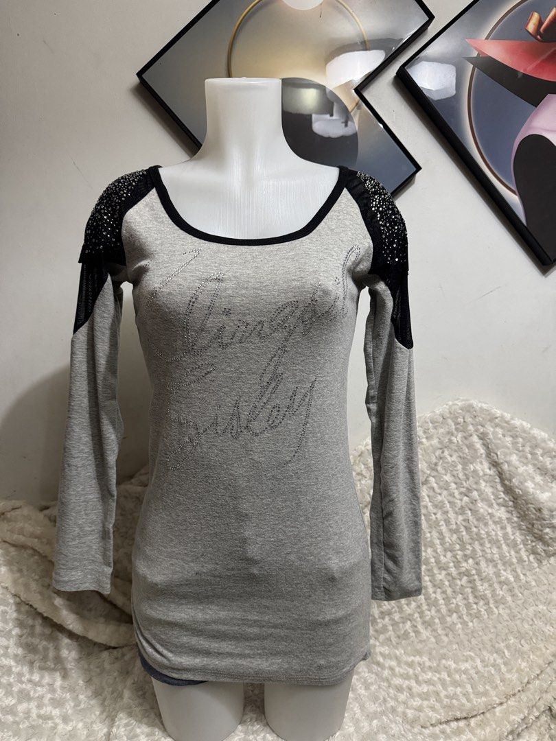 Grey Long Sleeve Top with Rhinestone Shoulders (Category: Longsleeves) located in Marikina City. Submitted by lorradel (Listing ID 1464894522, Image 1). Description: - fits S-M - Style: Fitted long sleeve top with a hip-length cut - Color: Grey with black trim along the scoop neckline - Details: Rhinestone embellishments and sheer fabric panels on shoulders and upper sleeves - Graphic: Rhinestone script lettering across the front chest - Material